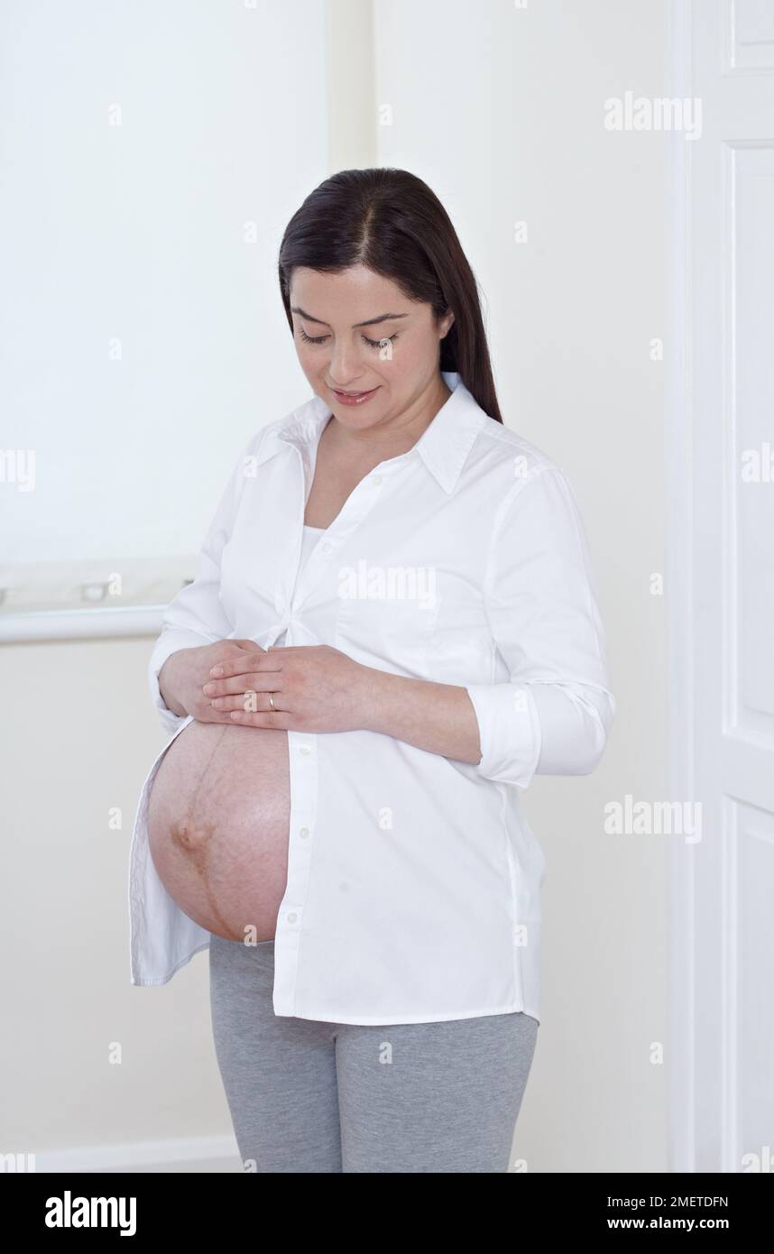 Femme lourdement enceinte avec son ventre exposé Banque D'Images