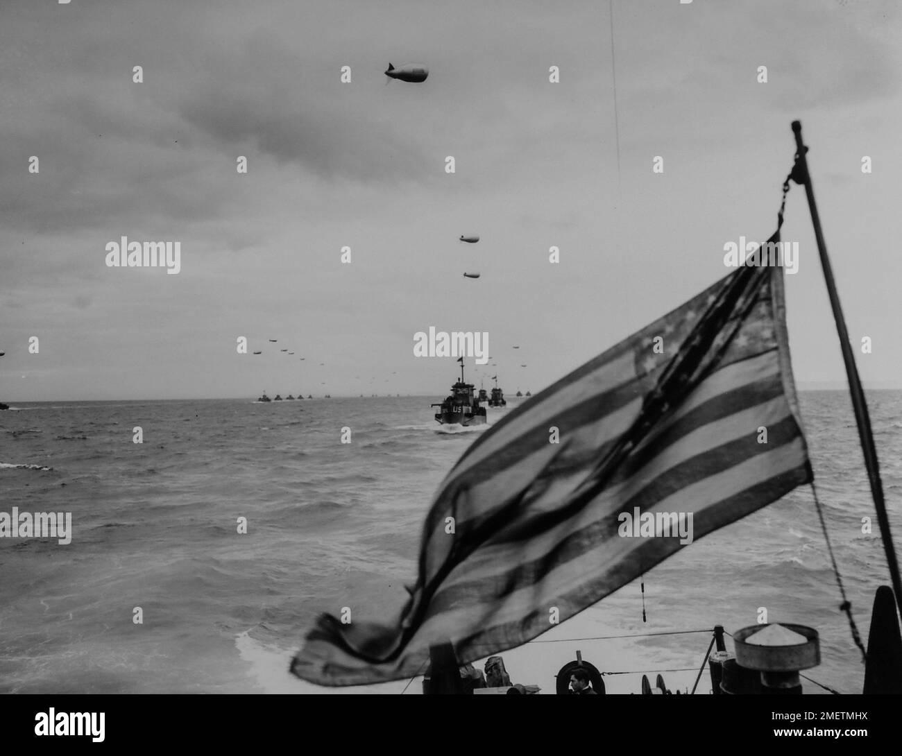 Photographie des colonnes de la Garde côtière LCI avançant sur les plages de France dans le sillage des étoiles et des rayures. Old Glory se déplace vers New Glory-Columns of Coast Guard LCI, protégé par des ballons de barrage contre les bas-volants nazis, avance sur les plages de France dans le sillage des étoiles et des rayures. Un photographe de combat de la Garde côtière, qui a pris part à l'invasion d'un LCI, a pris cette photo de l'avant-garde de la flotte de libération dans la Manche. 1939 - 1967. Banque D'Images