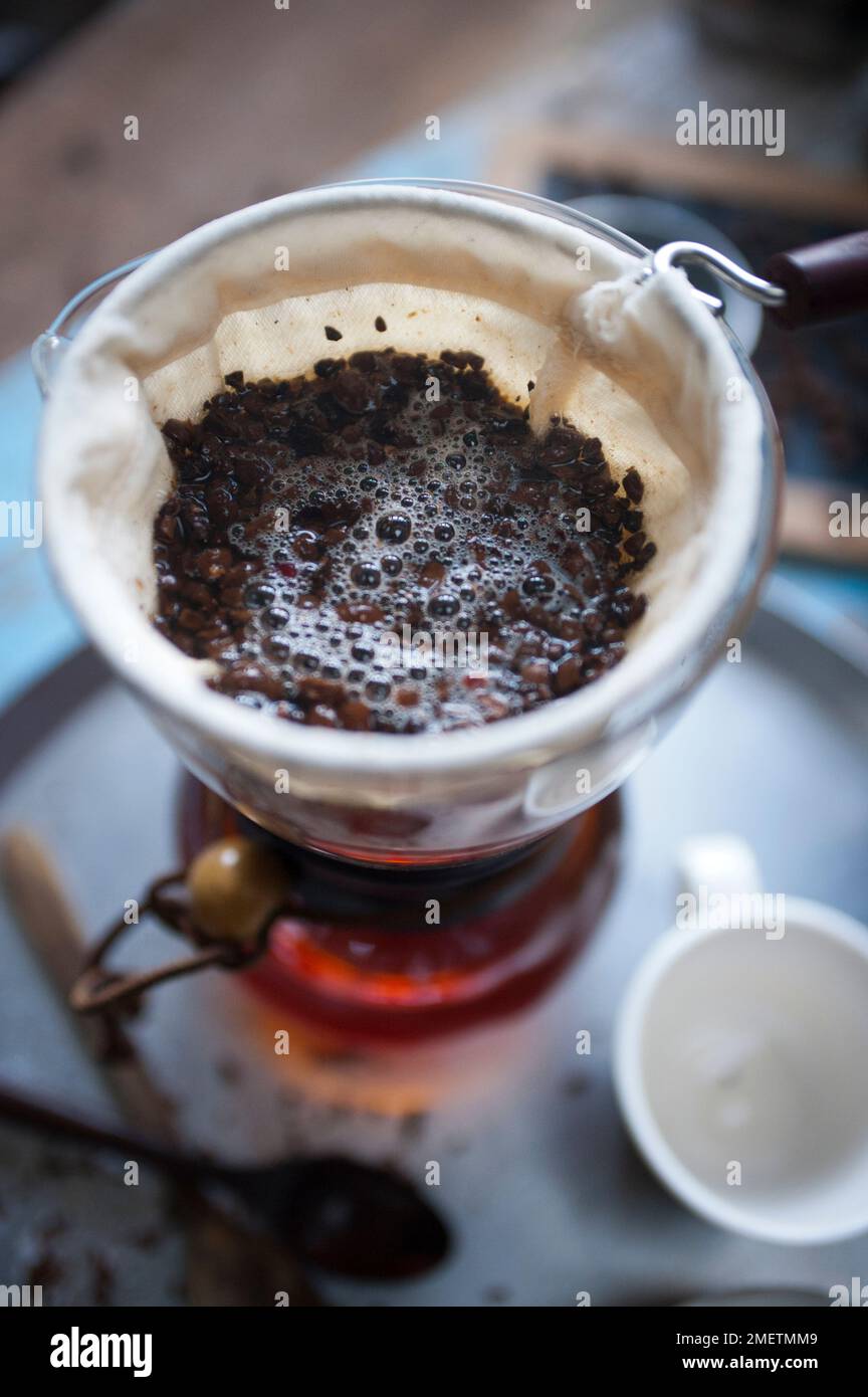 Caffe Touba, vidange du café par un chiffon dans une verseuse en verre Banque D'Images