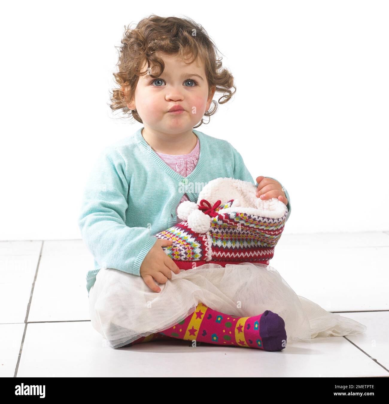 Petite fille assise avec une grande slipper sur ses genoux, 2 ans Banque D'Images
