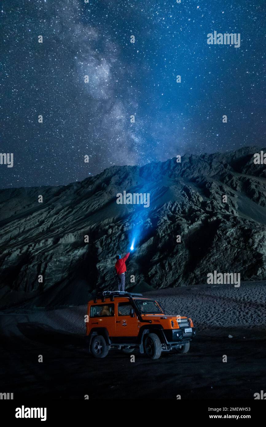 Ladakh, Inde - 24 août 2022: Image d'exposition longue extrême montrant la galaxie de Milkyway sur un véhicule de SUV offroad dans les montagnes de l'Himalaya. Banque D'Images