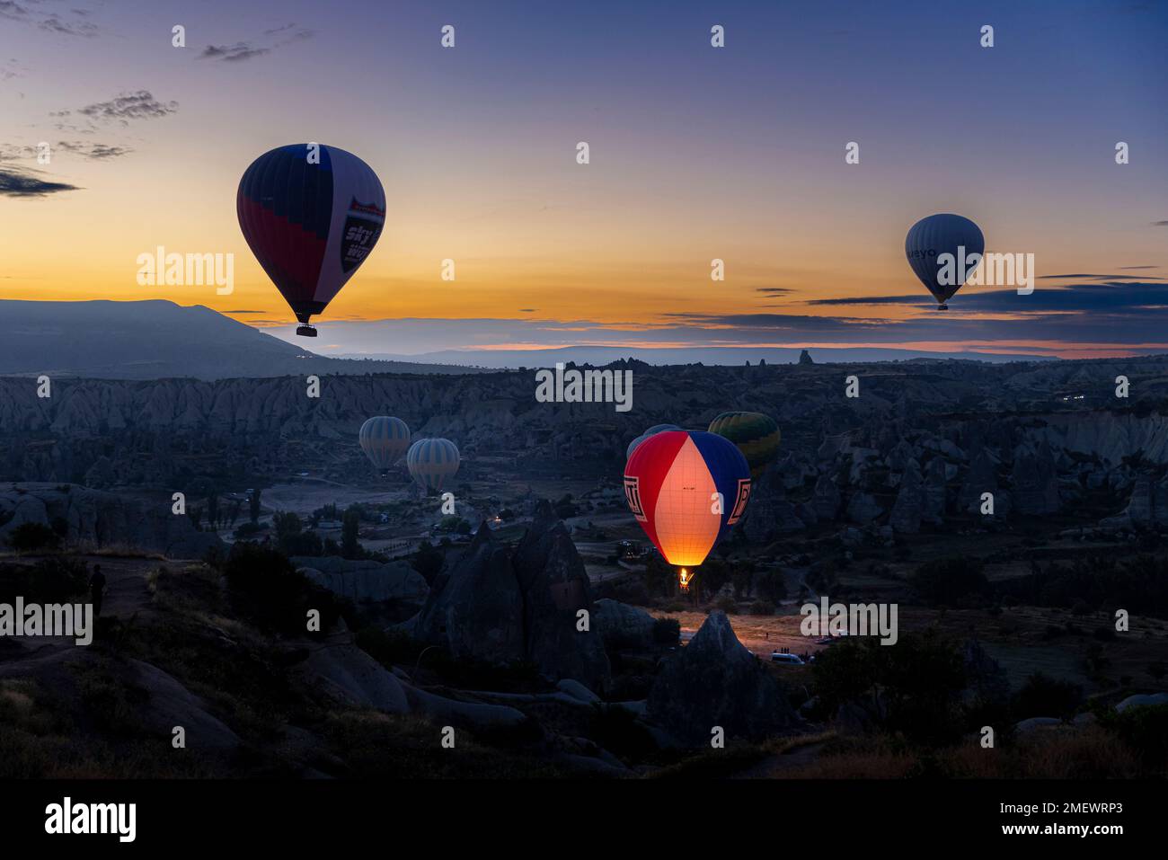 GÖREME/TURQUIE - 29 juin 2022 : des ballons à air chaud survolent à l'aube les collines de Göreme. Banque D'Images