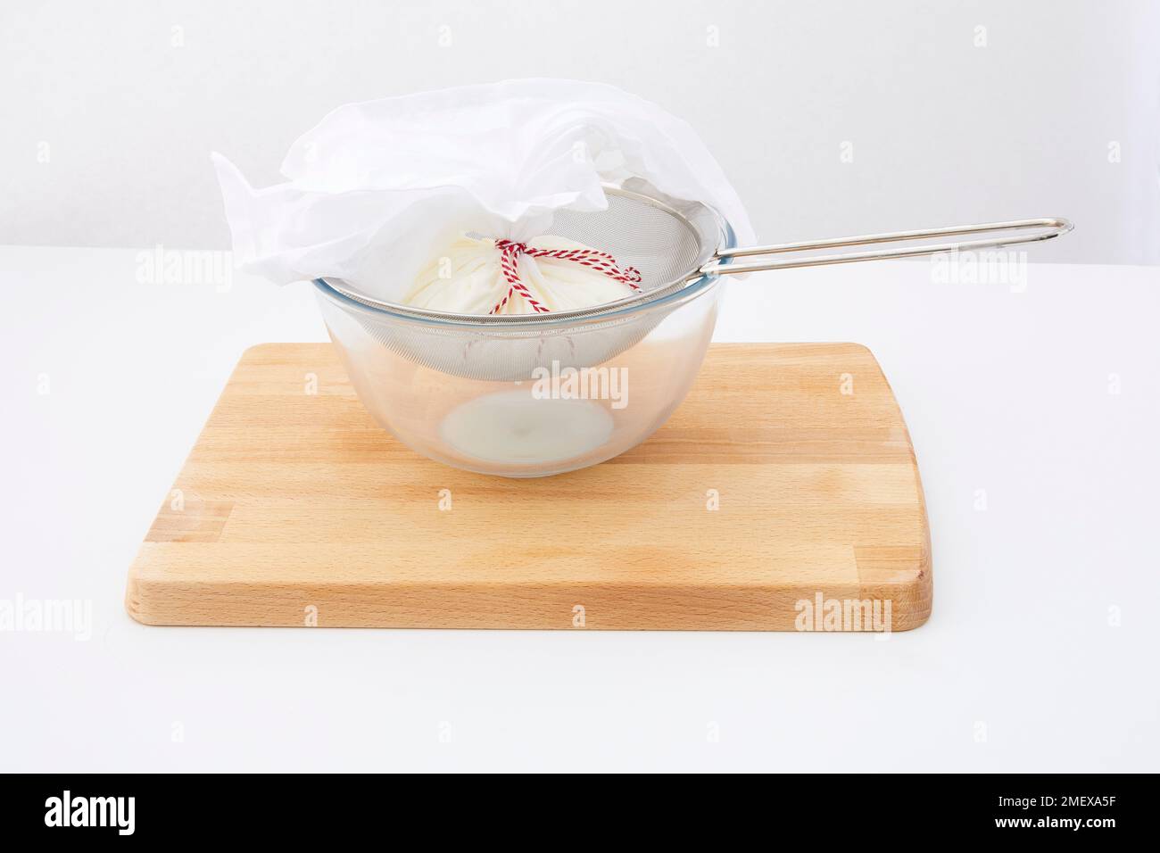 Préparation de Labneh - étape 2 - Cheese Cloth et assis dans le tamis, yaourt liquide s'égoutter dans le bol Banque D'Images