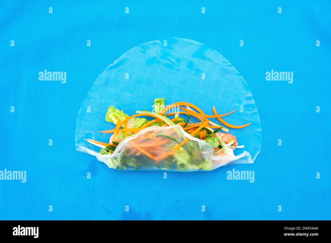 Rouleaux de crevettes d'été - étape 1 - Remplissez l'emballage avec les crevettes et les légumes, pliez par le bas Banque D'Images