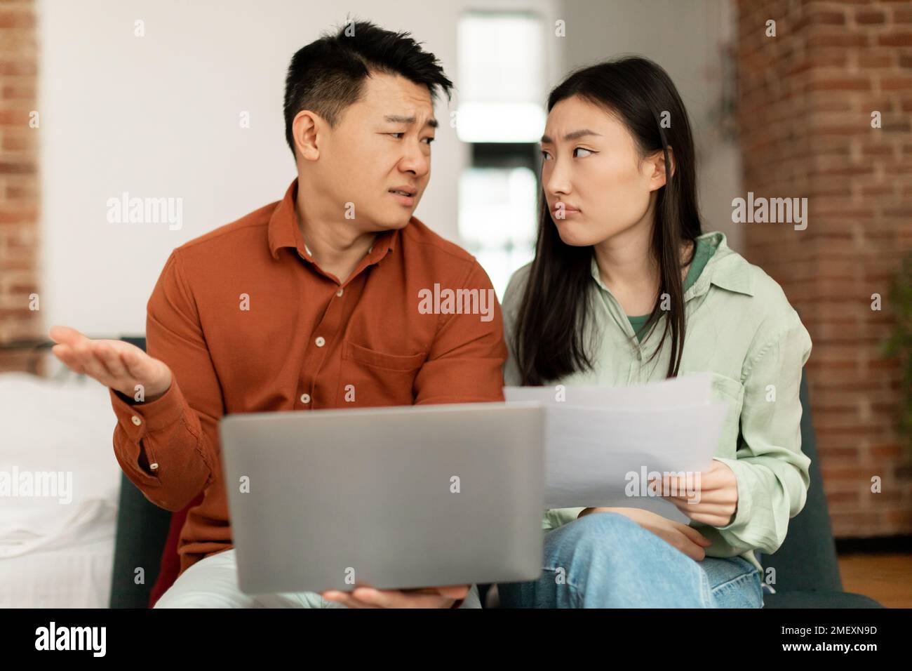 Concept de crise financière. Contrarié couple asiatique de vérifier des documents à la maison, souffrant de problèmes avec la gestion du budget familial Banque D'Images