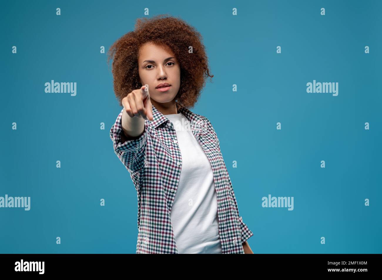 Jeune femme pointant vers quelqu'un avec son doigt et un regard de blâme Banque D'Images