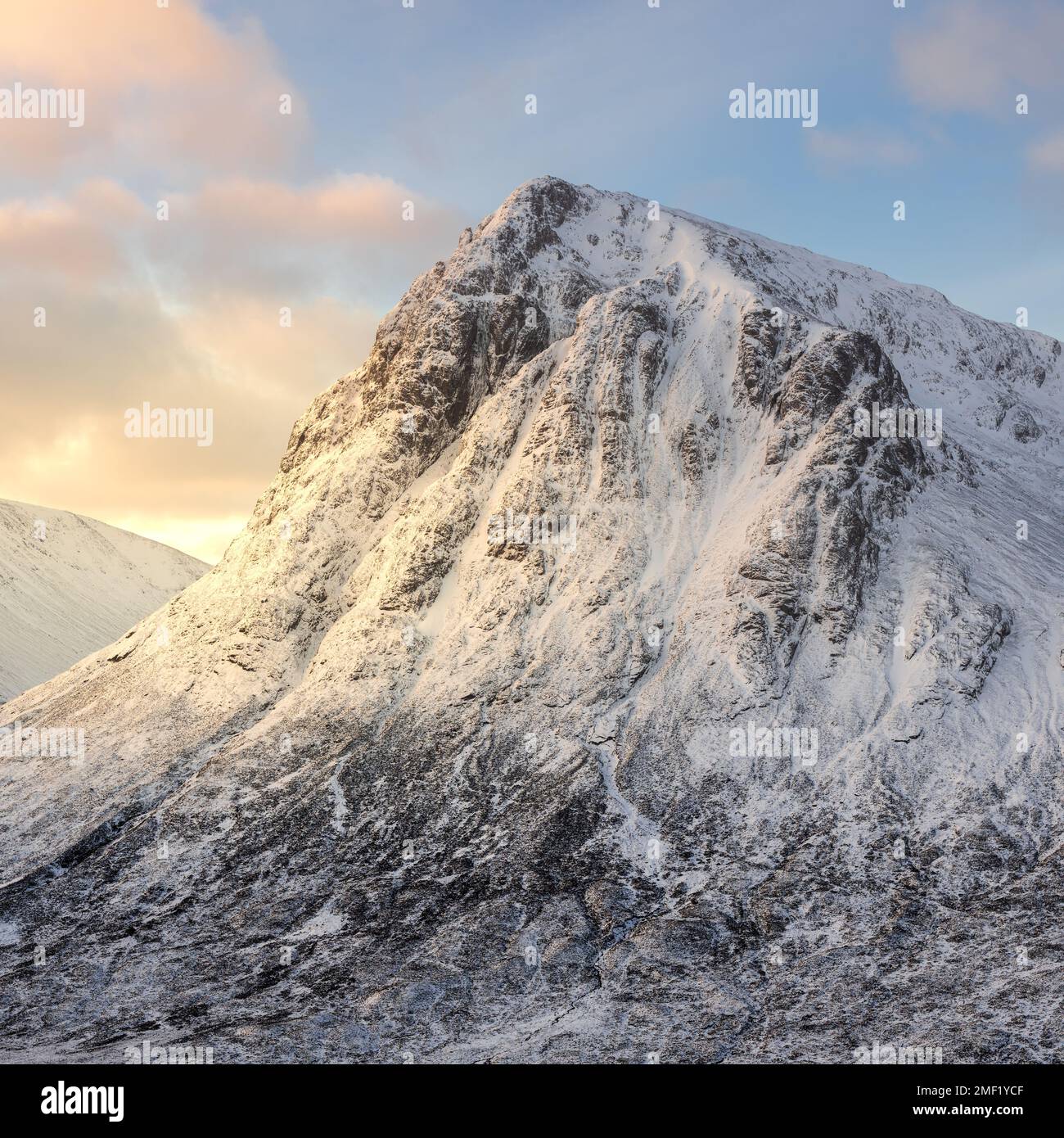 Buachille Etive Mor montagne de montagne couverte de neige avec lumière dorée du matin. Glencoe, Scottish Highlands, Royaume-Uni. Banque D'Images