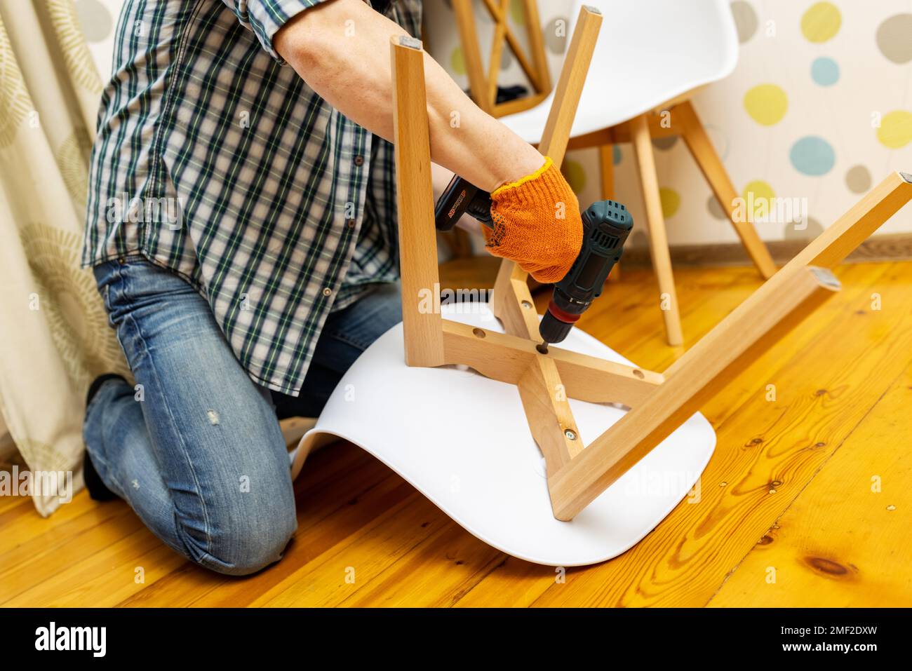 Assembler les meubles. Homme assemblant la chaise. Assembleur de meubles avec perceuse Banque D'Images