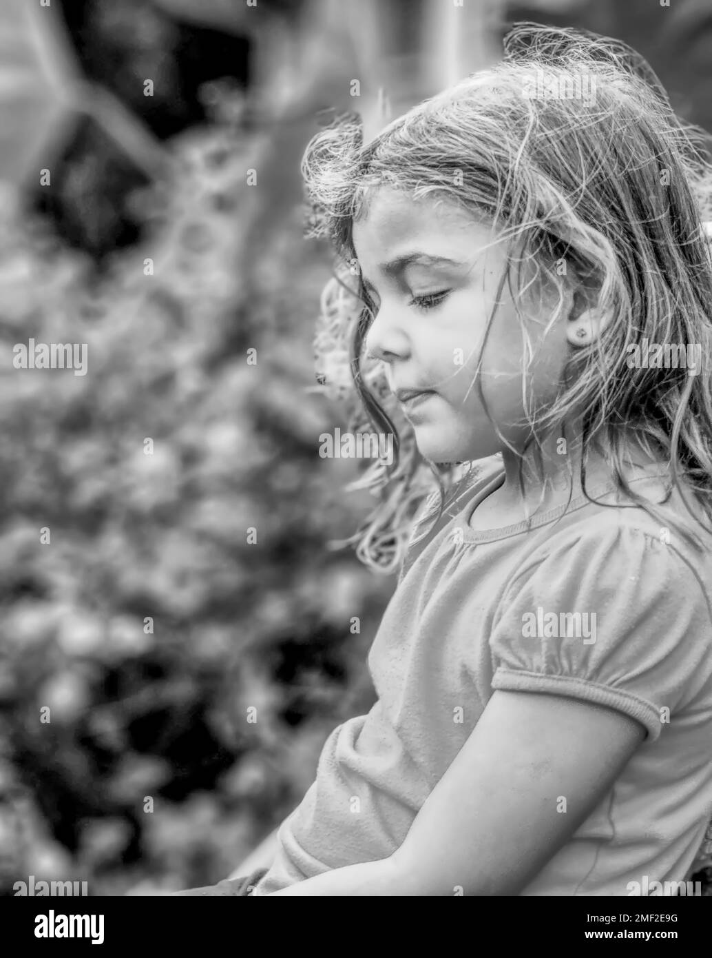Photo de côté d'une petite fille à l'extérieur, en noir et blanc Banque D'Images