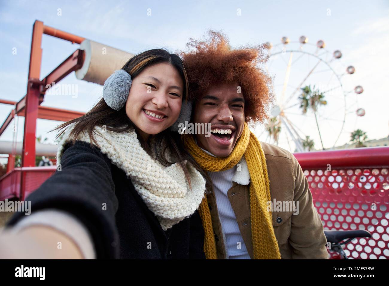 Jeune couple de course mixte en vêtements d'hiver prenant un selfie à l'extérieur. Banque D'Images