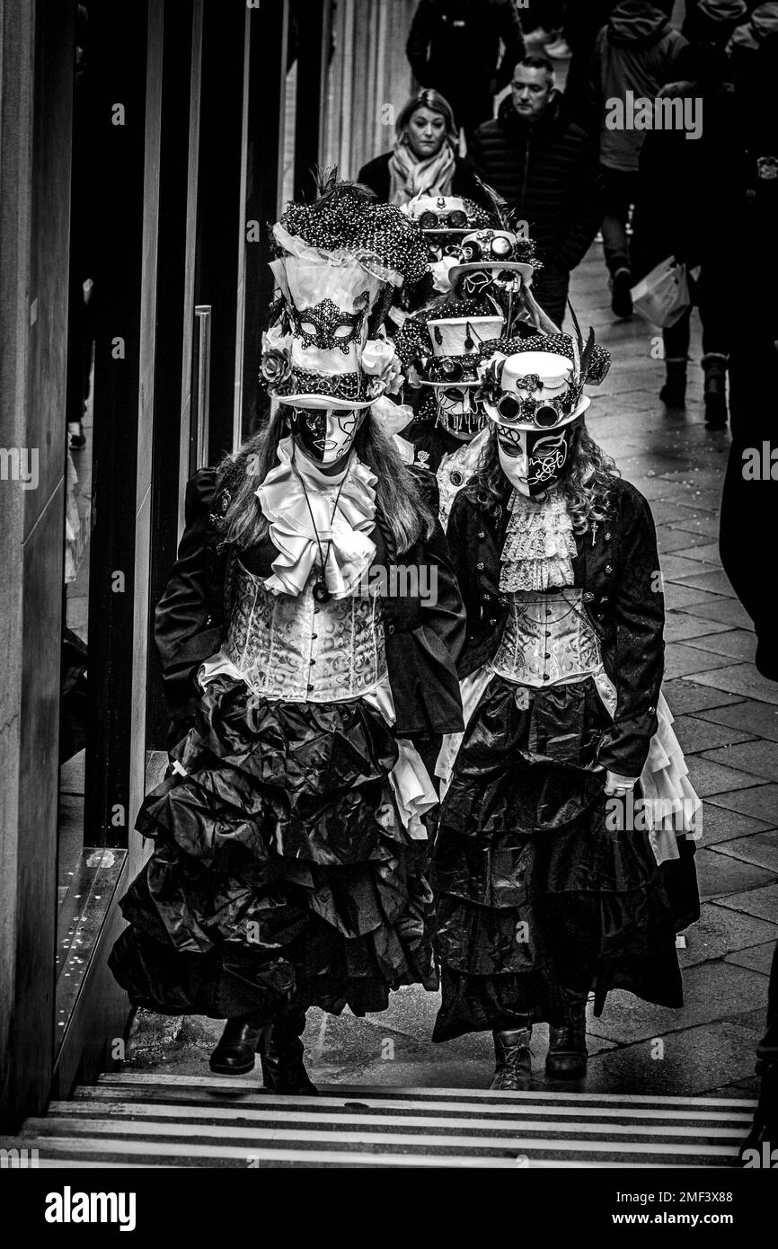 Un groupe de filles vêtues de robes médiévales et de masques de carnaval se promènent dans la rue à Venise, en Italie Banque D'Images
