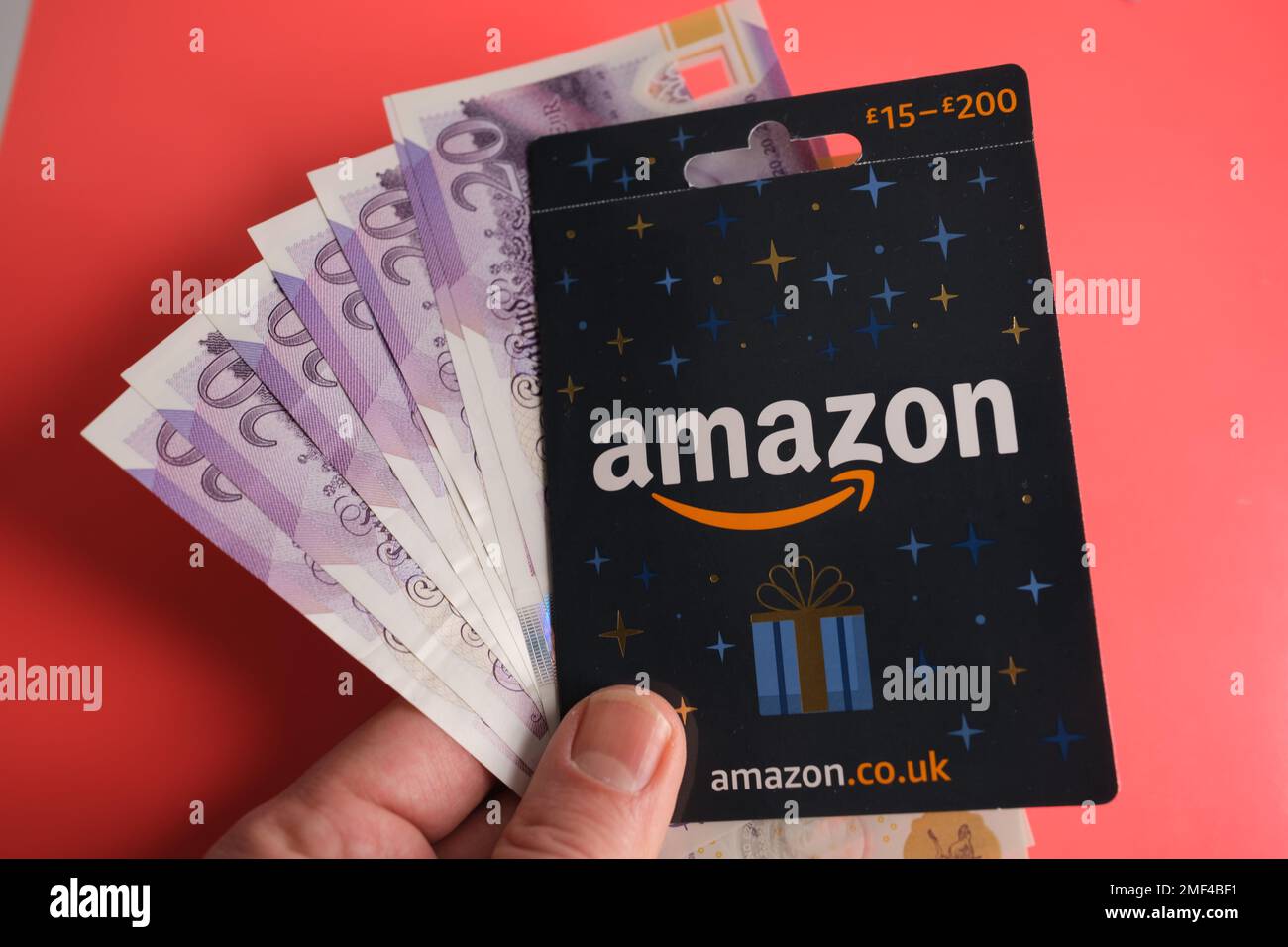 Carte-cadeau Amazon : image rapprochée et retenue d'argent dans une main. Stafford, Royaume-Uni, 24 janvier 2023 Banque D'Images