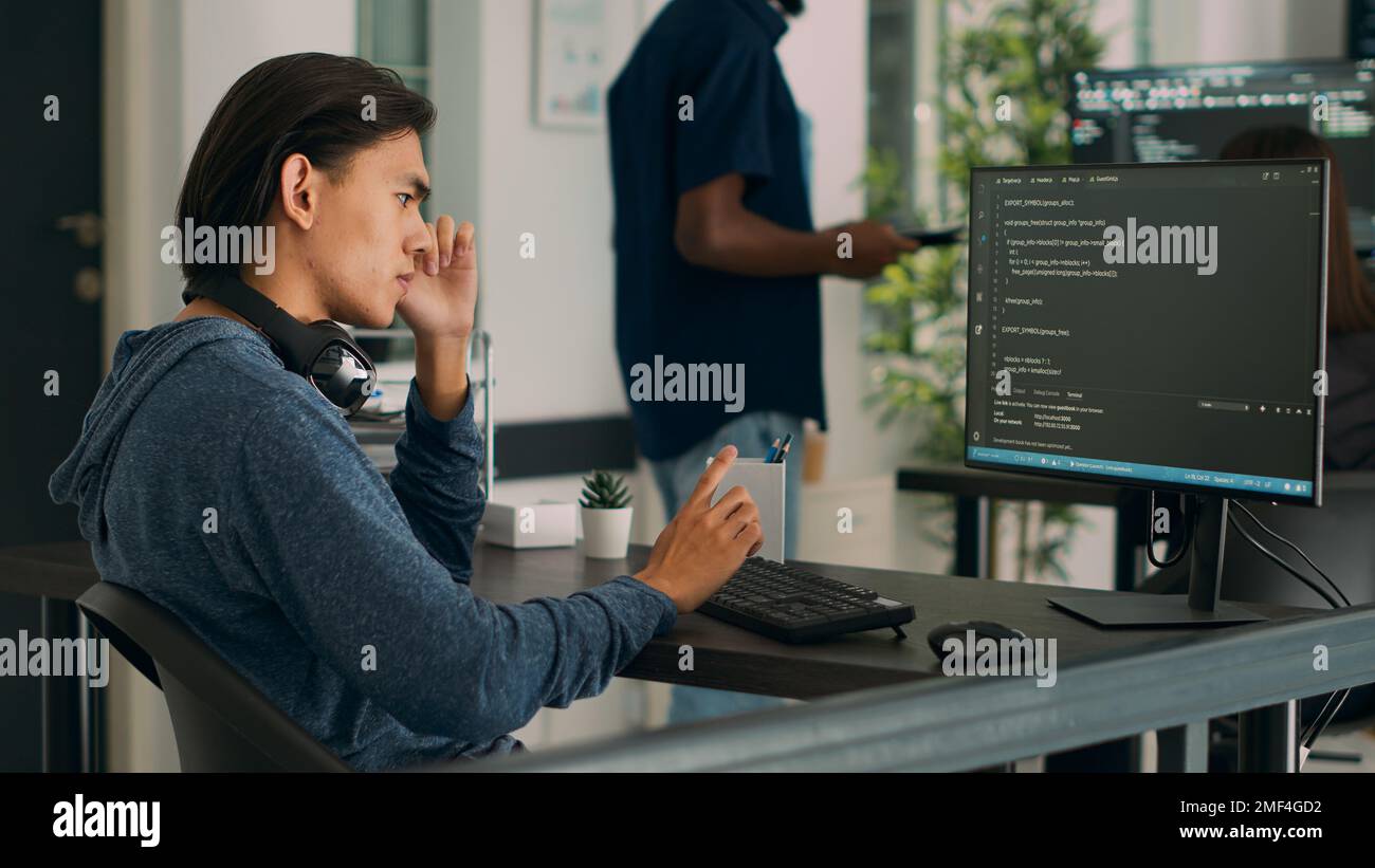 Un programme de base de données asiatique écrit du code sur un ordinateur affichant un algorithme d'intelligence artificielle. Développeur de logiciels travaillant sur l'interface de codage avec des informations de serveur, Big Data. Banque D'Images