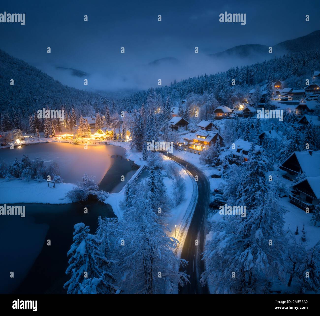 Vue aérienne de la ville dans la neige, la route, la forêt, le lac et les maisons Banque D'Images