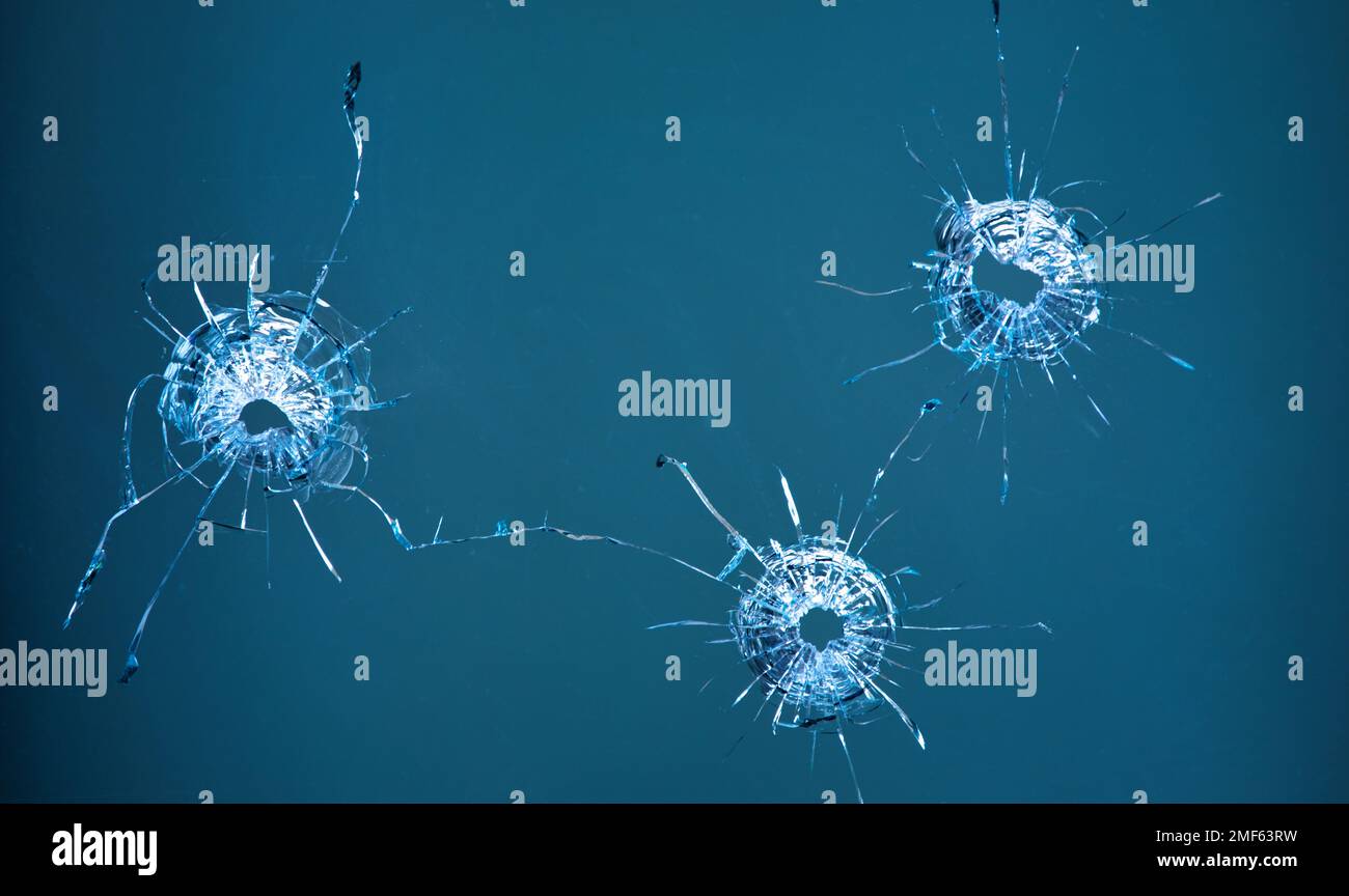 Collage de fissures dans le verre, un trou de balles dans le verre sur un fond noir. Texture de verre de fenêtre. Banque D'Images