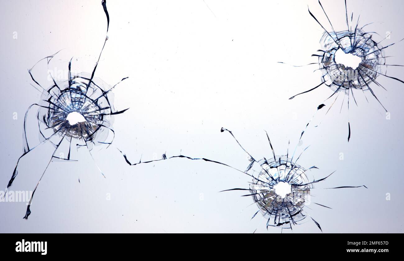 Collage de fissures dans le verre, un trou de balles dans le verre sur un fond noir. Texture de verre de fenêtre. Banque D'Images