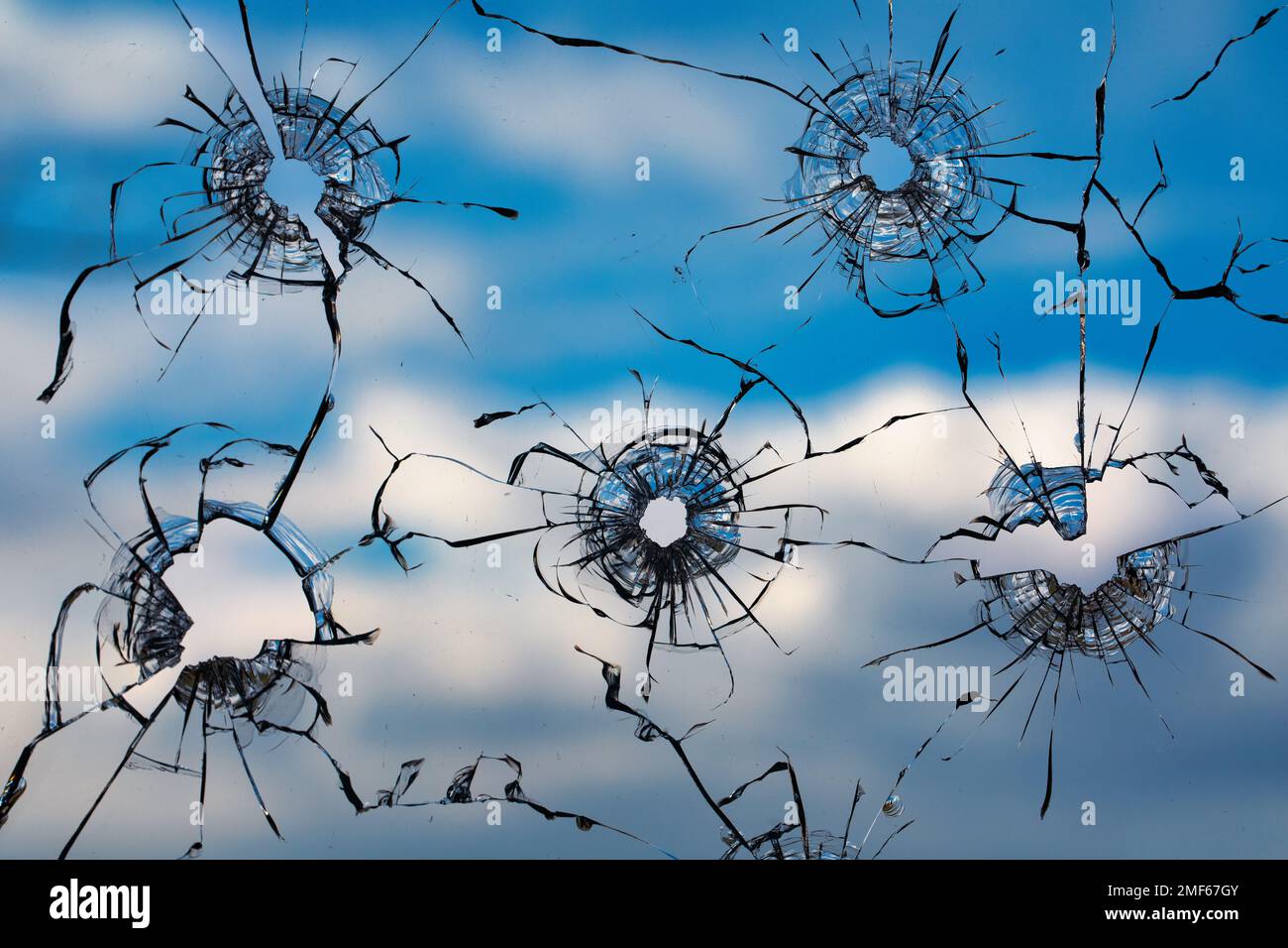 Collage de fissures dans le verre, un trou de balles dans le verre sur un fond noir. Texture de verre de fenêtre. Banque D'Images