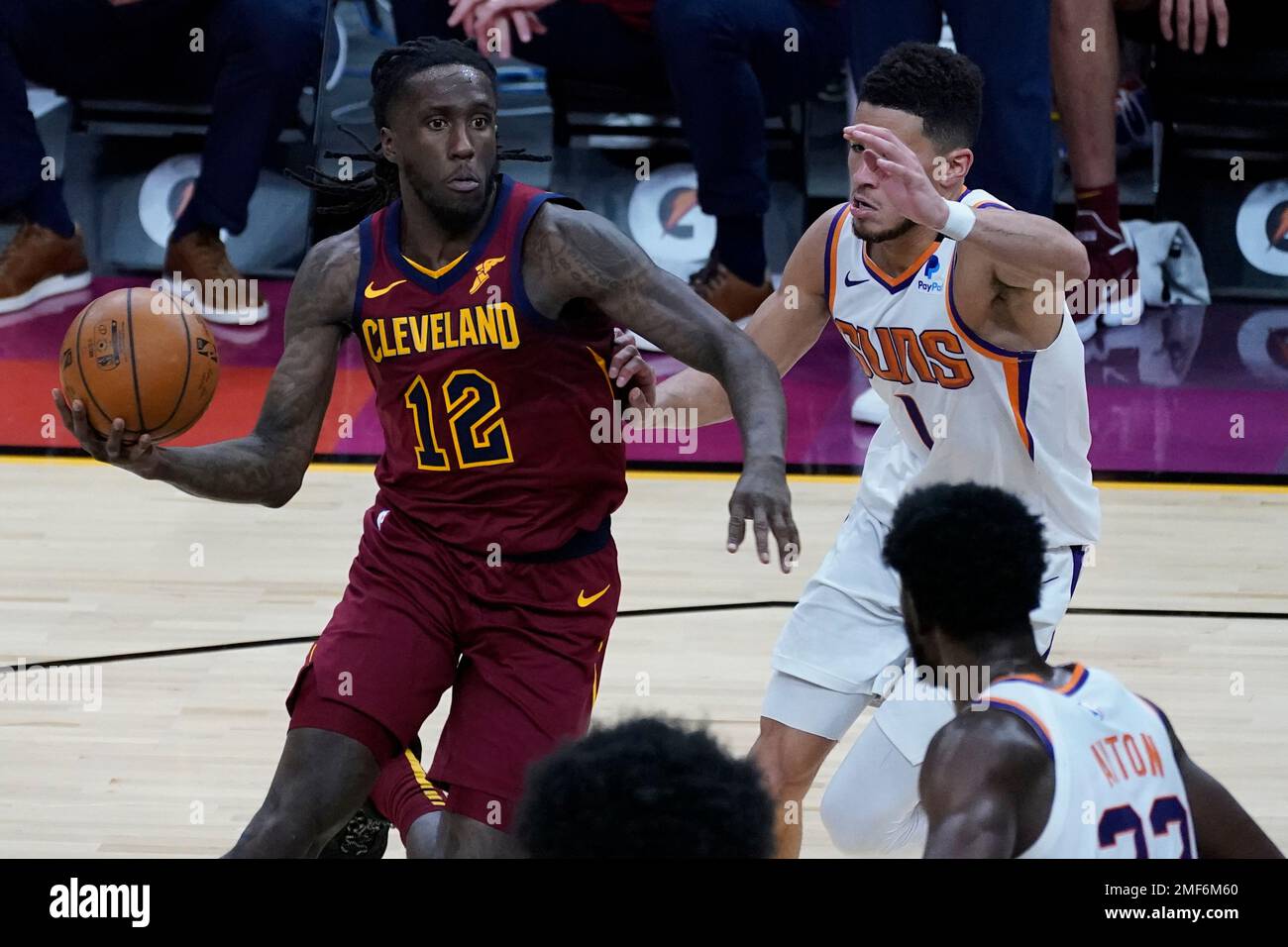 Cleveland Cavaliers forward Taurean Prince (12) drives past Phoenix Suns guard Devin Booker (1) during the first half of an NBA basketball game, Monday, Feb. 8, 2021, in Phoenix. (AP Photo/Matt York) Banque D'Images
