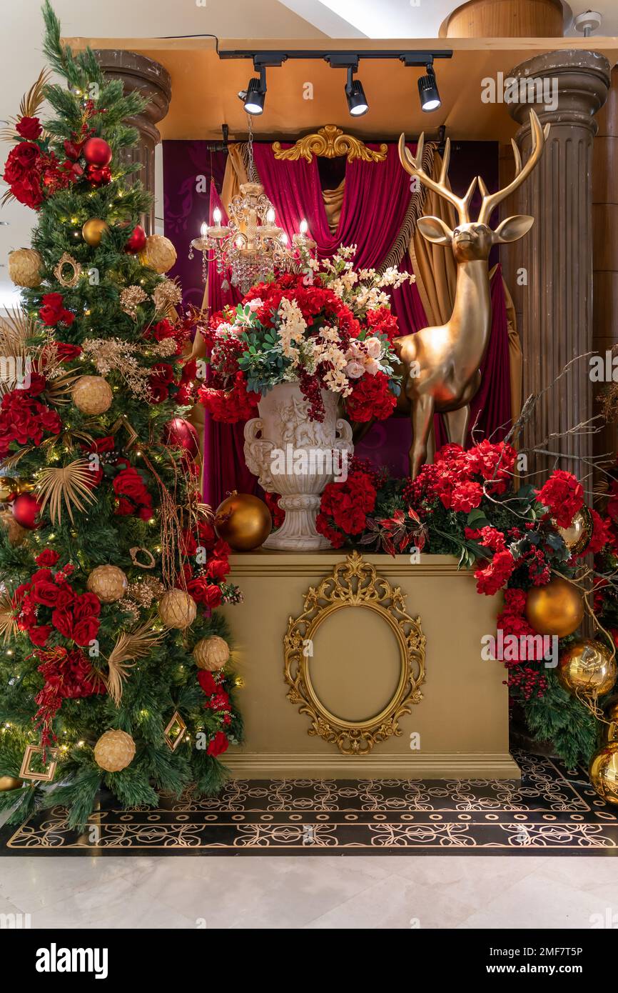 Vue intérieure de Noël sur un cerf avec des fleurs colorées et un arbre de noël comme arrière-plan. Banque D'Images