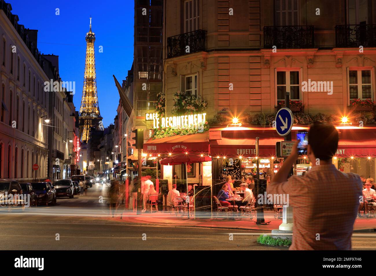 Vue de nuit de la Tour Eiffel et du café le Recrutement au coin de la rue Saint-Dominique et du boulevard de la Tour-Maubourg avec des véhicules à feux arrière.Paris.France Banque D'Images