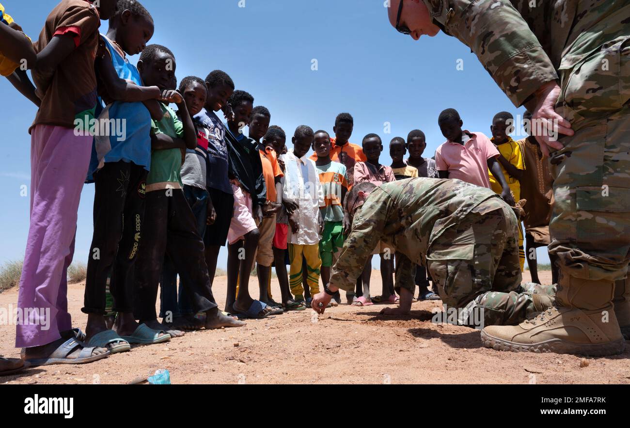 AGADEZ, Niger - les militaires américains stationnés à la base aérienne nigérienne 201 prennent du temps en dehors de leur horaire chargé pour passer quelques minutes à divertir les enfants locaux d'Agadez, Niger, 18 août 2022. ÉTATS-UNIS Les soldats du bataillon des affaires civiles de 443th, affectés à l'équipe des affaires civiles du Groupe expéditionnaire aérien de 409th, encouragent un partenariat durable avec Agadez. Banque D'Images