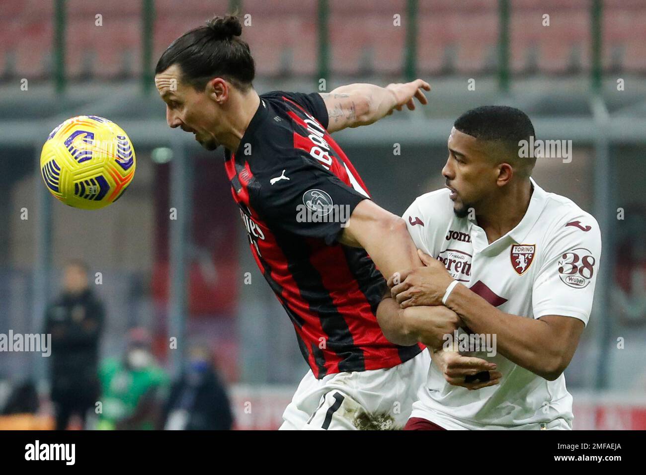 AC Milan's Zlatan Ibrahimovic, left, is challenged by Torino's Gleison Bremer during the Italian Cup round of 16 soccer match between AC Milan and Torino at the San Siro stadium, in Milan, Italy, Tuesday, Jan. 12, 2021. (AP Photo/Antonio Calanni) Banque D'Images