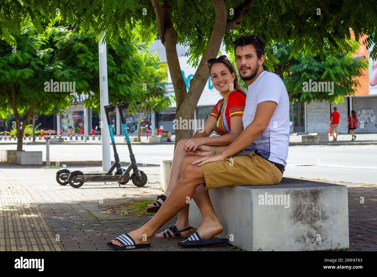 couple assis sur un banc sur le trottoir de la rue Banque D'Images