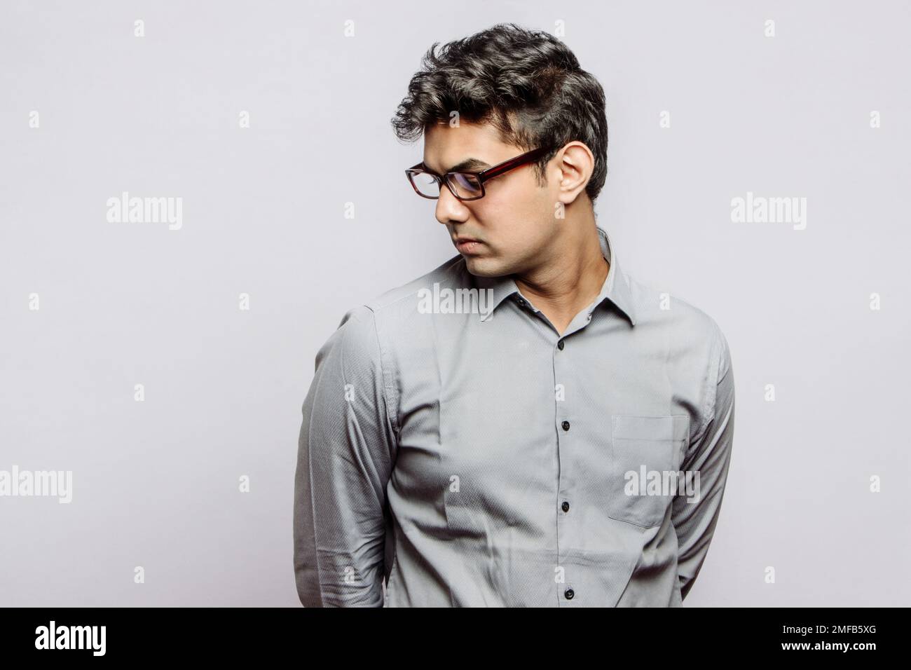 Confiant Indian Corporate Business Tycoon homme regardant en arrière, exsudant le leadership, l'autorité et le professionnalisme dans un cadre minimaliste avec Copyspace Banque D'Images