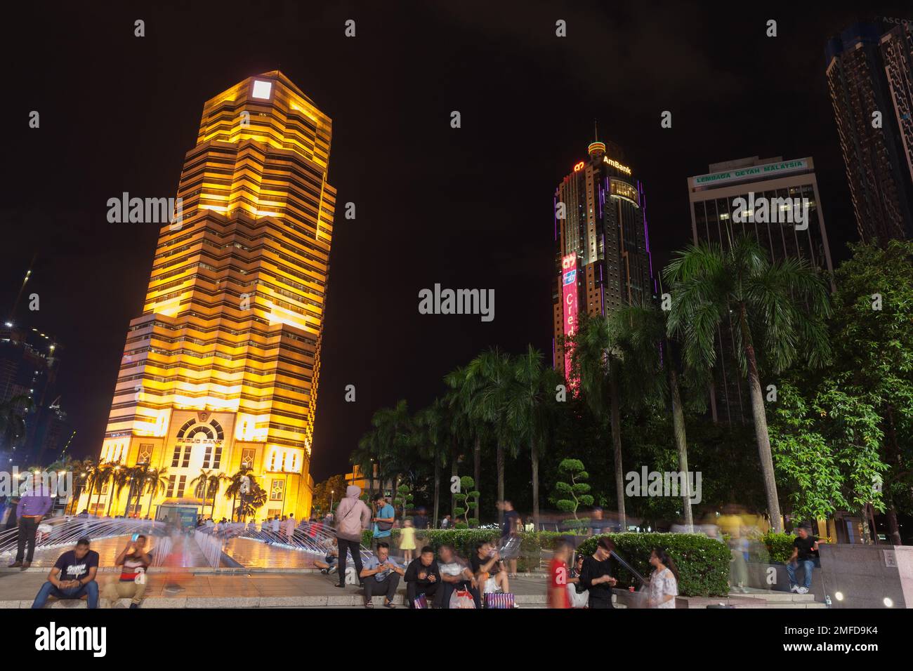 Kuala Lumpur, Malaisie - 28 novembre 2019: Kuala Lumpur centre-ville la nuit, vue sur la rue avec le bâtiment de la Banque publique. Les gens ordinaires marchent dans la rue Banque D'Images