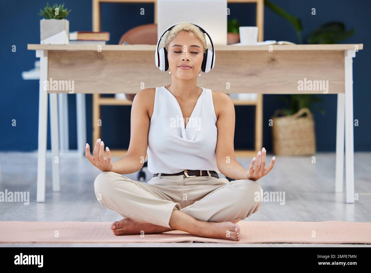 Musique, méditation et yoga avec une femme noire d'affaires trouvant la paix intérieure ou zen dans son bureau. Casque, santé mentale et équilibre avec un calme Banque D'Images