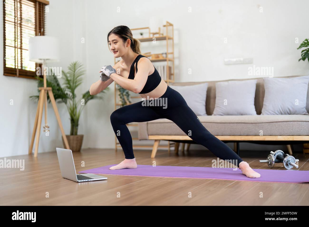FIT asian femme entraînement fitness sport entraînement en ligne sur ordinateur portable à la maison Banque D'Images