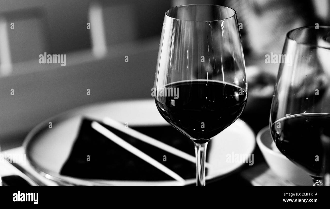 Une photo monochrome des verres de vin rouge Banque D'Images