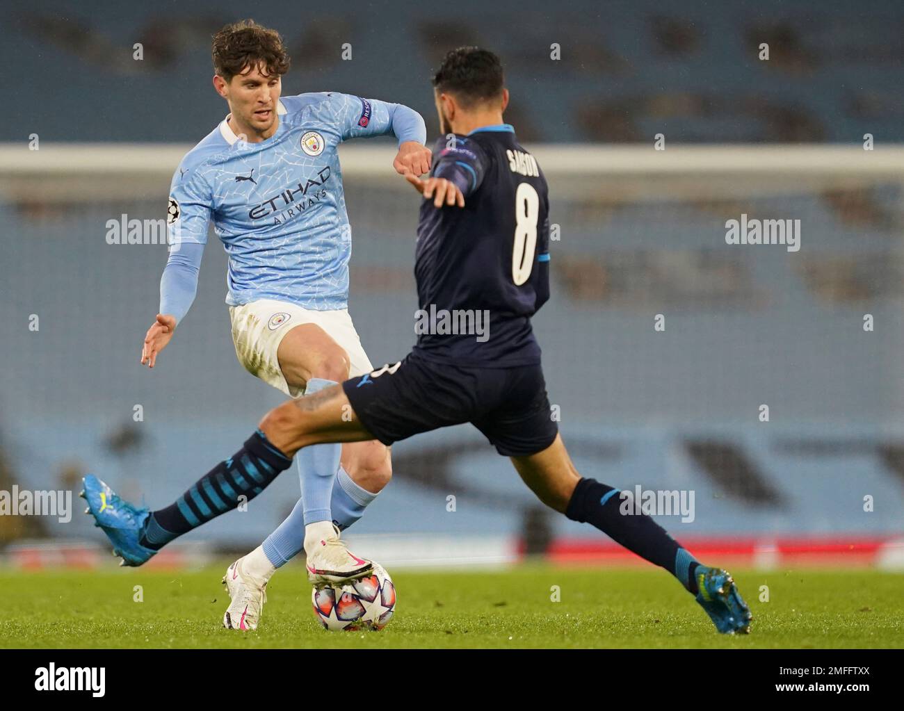 Manchester City's John Stones, left, is challenged by Marseille's Morgan Sanson during the Champions League, Group C, soccer match between Manchester City and Marseille at the Etihad stadium in Manchester in London Wednesday, Dec. 9, 2020. (AP Photo/Jon Super) Banque D'Images