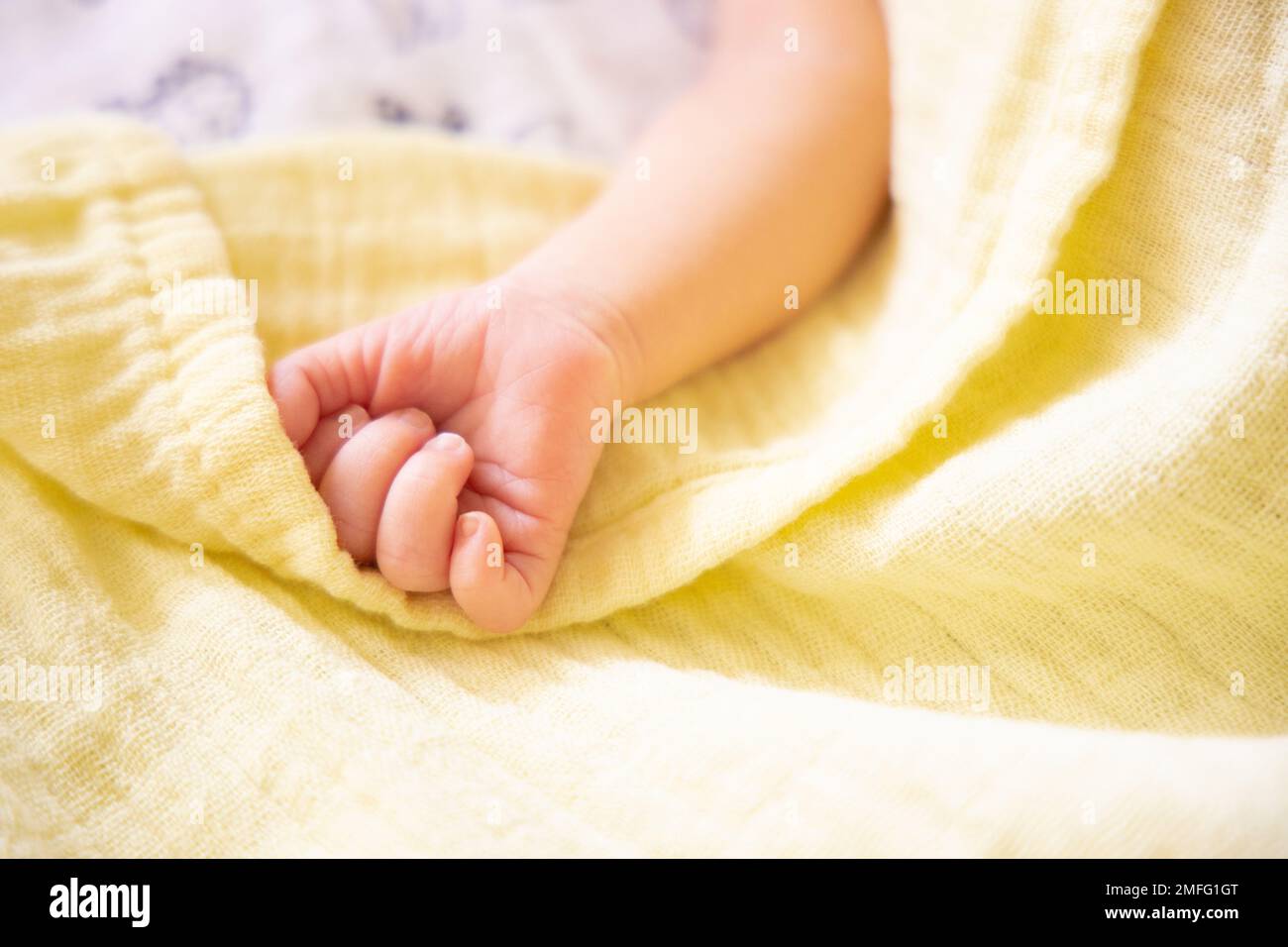 Nouveau-né prématuré main sur couverture souple jaune pastel mousseline.  Espace de copie, espace pour le texte Photo Stock - Alamy