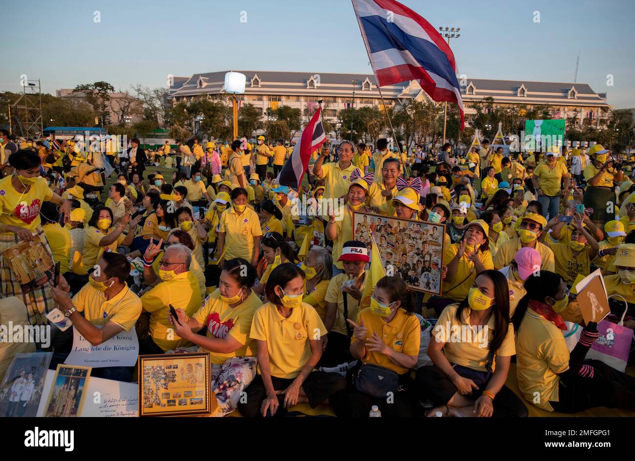 Supporters of Thai monarch display images of King Maha Vajiralongkorn, Queen Suthida and late King Bhumibol Adulyadej ahead of the arrival of king and queen to participate in a candle lighting ceremony to mark birth anniversary of late King Bhumibol Adulyadej at Sanam Luang ceremonial ground in Bangkok, Thailand, Saturday, Dec. 5, 2020. (AP Photo/Gemunu Amarasinghe) Banque D'Images