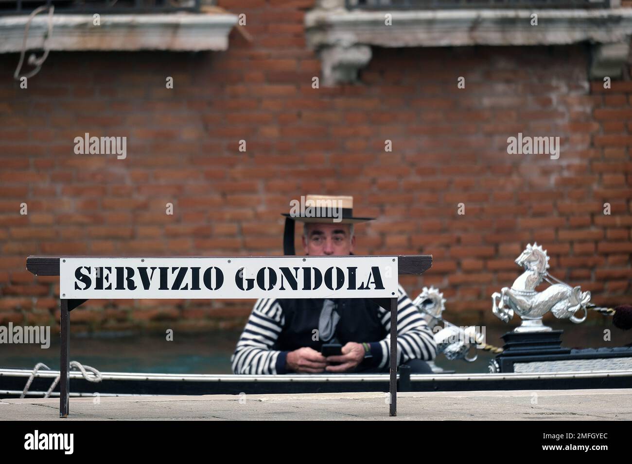 Un gondolier se trouve dans sa gondole à Venise. Italie Banque D'Images