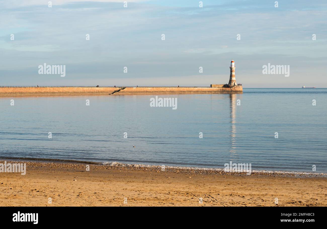 Météo au Royaume-Uni 24-1-2023 le phare de Roker se reflète dans une mer lisse, Sunderland, Angleterre, Royaume-Uni Banque D'Images
