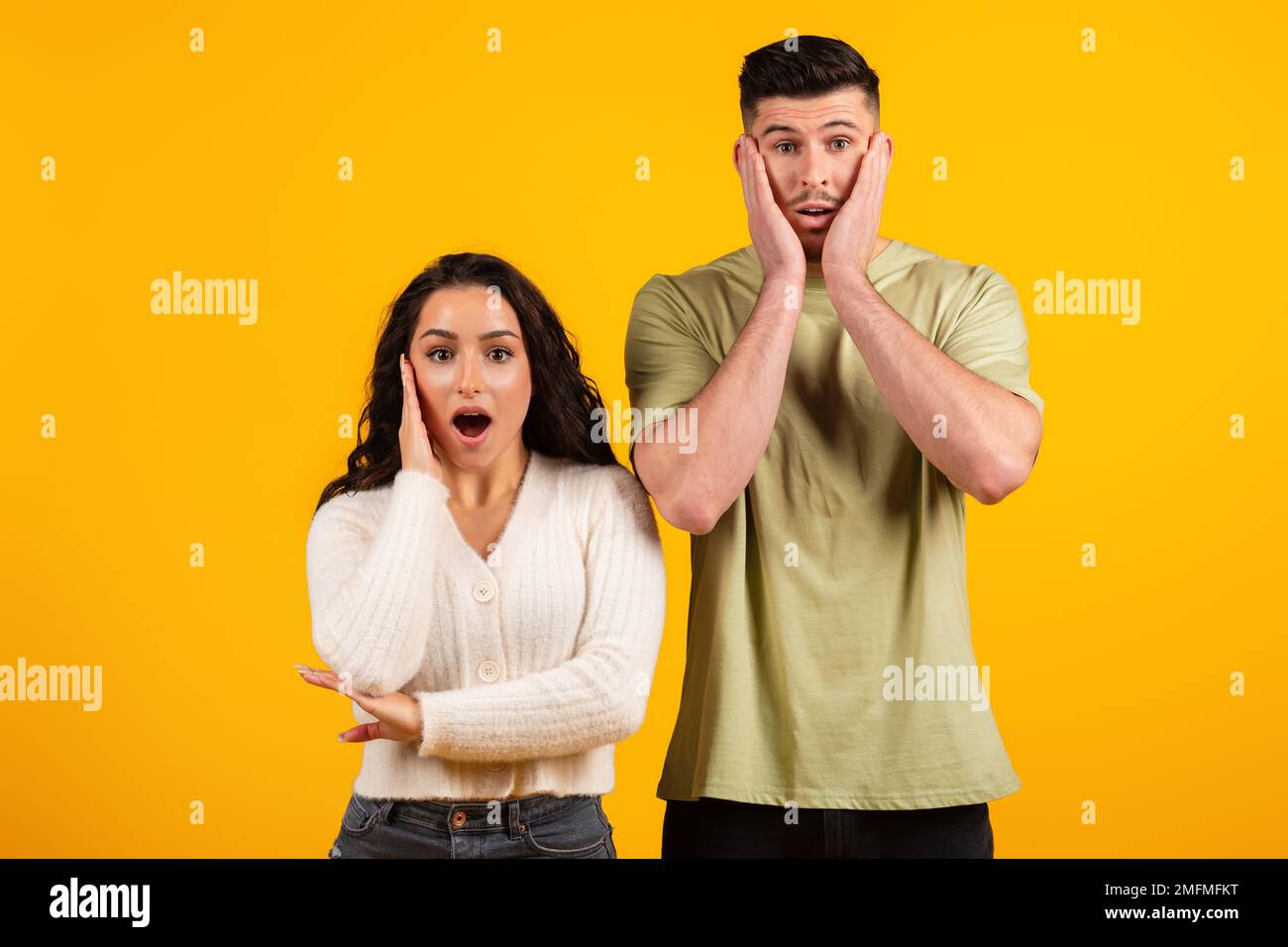 Magnifique et choqué jeune mari arabe et femme avec la bouche ouverte regardant la caméra Banque D'Images