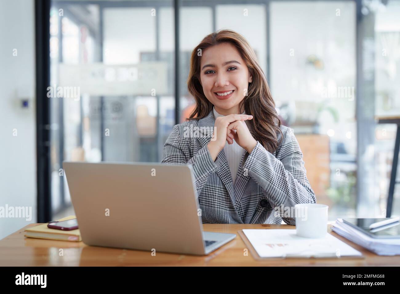 Portrait d'une femme d'affaires asiatique souriante avec ordinateur portable au bureau. Femme en costume au bureau Banque D'Images
