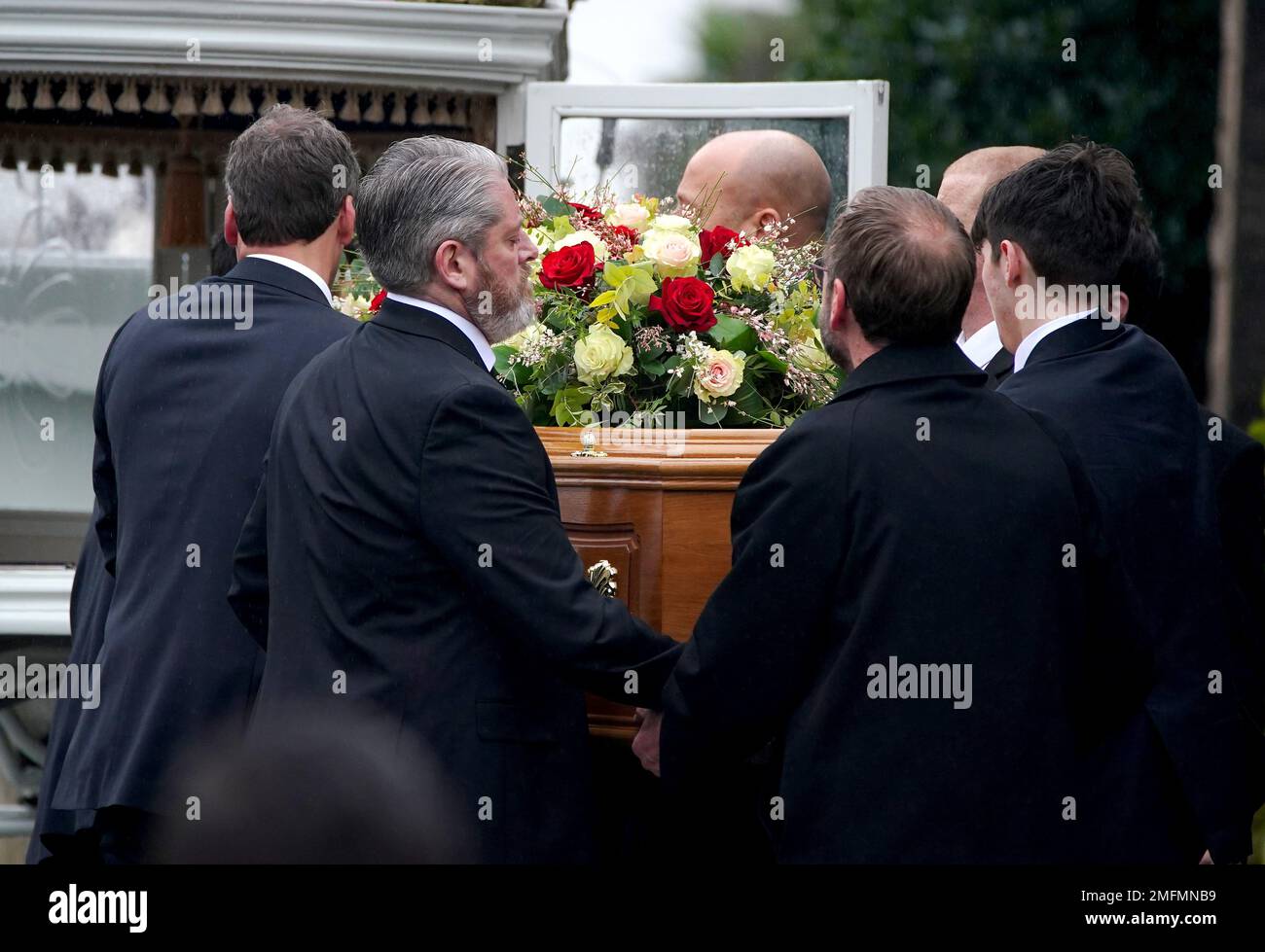 Le porteur, dont le père Tim Edwards (deuxième à gauche), lève le cercueil  d'elle Edwards dans une voiture après son service funéraire à l'église  Saint-Nicolas de Wallasey. Date de la photo: Mercredi