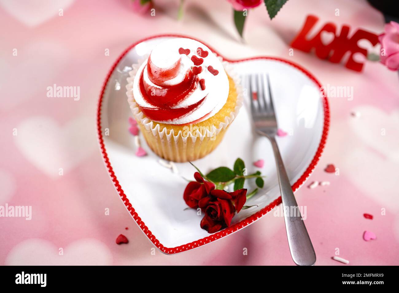 Saint-Valentin tourbillons de cupcake avec glaçage blanc rouge et roses | fond de dessert de jour de Saint-Valentin, foyer sélectif Banque D'Images