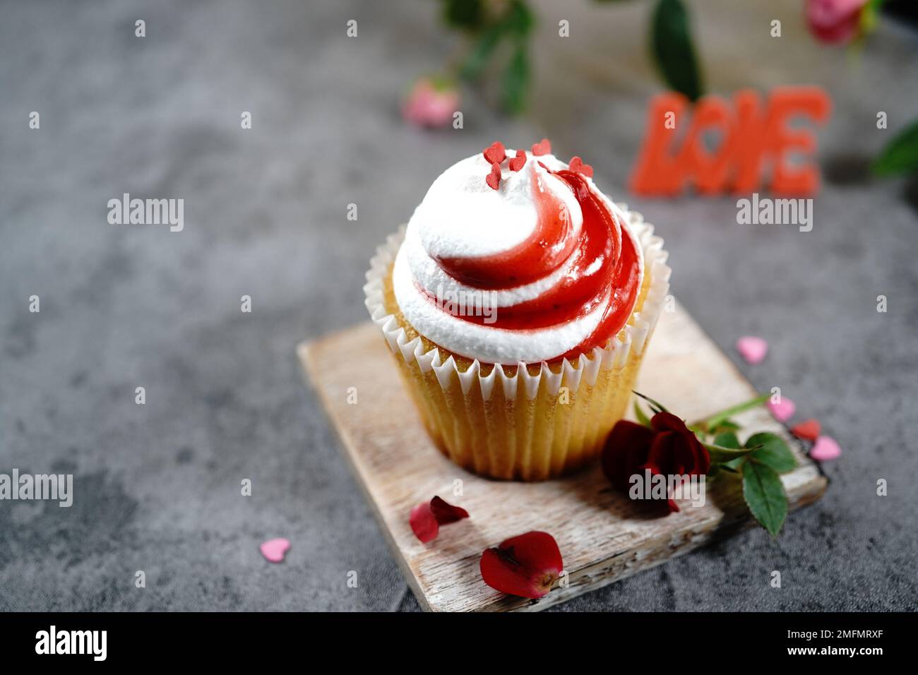 Saint-Valentin tourbillons de cupcake avec glaçage blanc rouge et roses | fond de dessert de jour de Saint-Valentin, foyer sélectif Banque D'Images