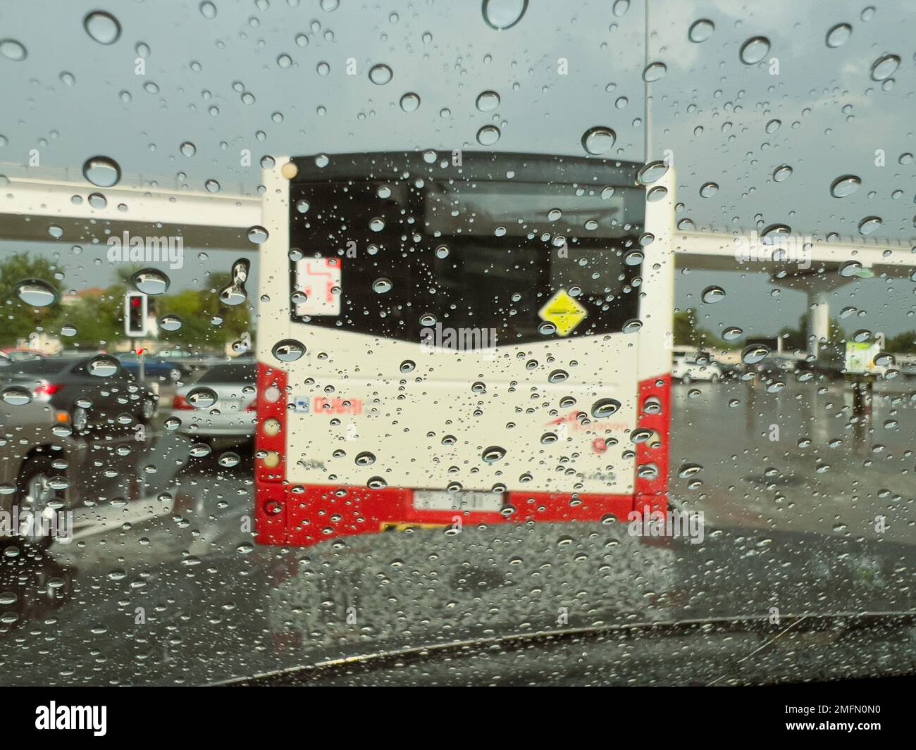 Mise au point sélective et flou de mouvement des gouttes de pluie sur le pare-brise d'un véhicule en circulation pendant une descente à Dubaï, Unite Arab Emirates. Banque D'Images