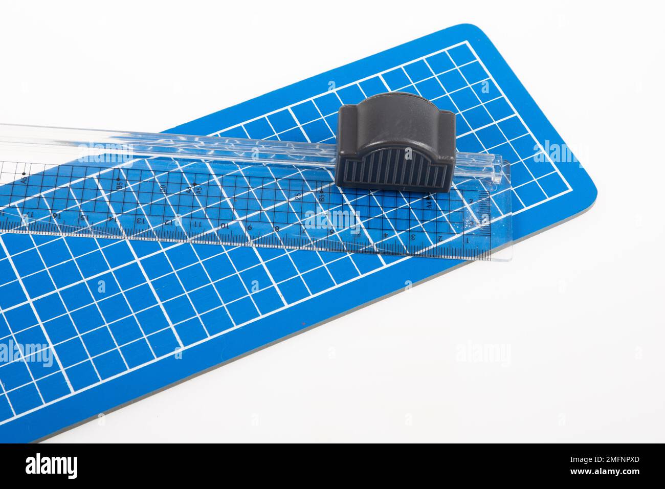 tapis de coupe et coupe-règle bleus sur fond blanc Banque D'Images