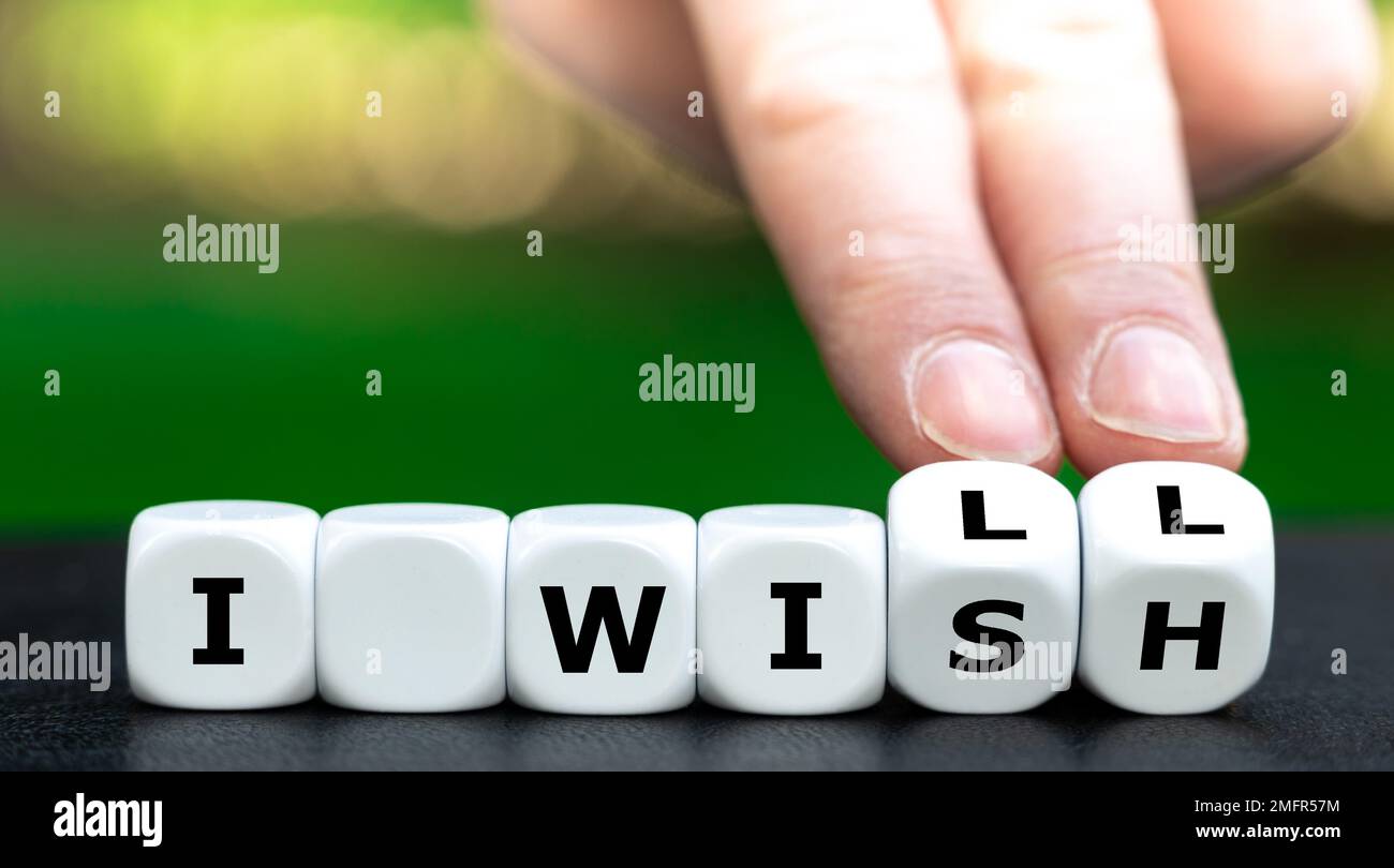 La main tourne les dés et change l'expression « Je souhaite » en « Je vais ». Banque D'Images
