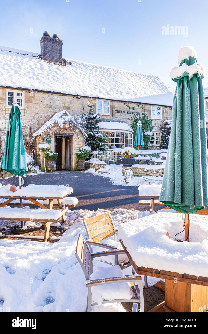 Début de l'hiver neige au Green Dragon Inn Pub dans le village de Cotswold de Cockleford près de Cowley, Gloucestershire, Angleterre Banque D'Images