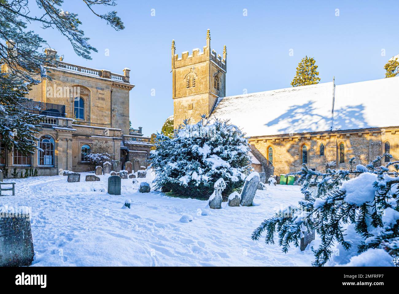 Début de l'hiver neige sur l'église de St Mary à côté de Cowley Manor Hotel dans le village Cotswold de Cowley, Gloucestershire, Angleterre Royaume-Uni Banque D'Images