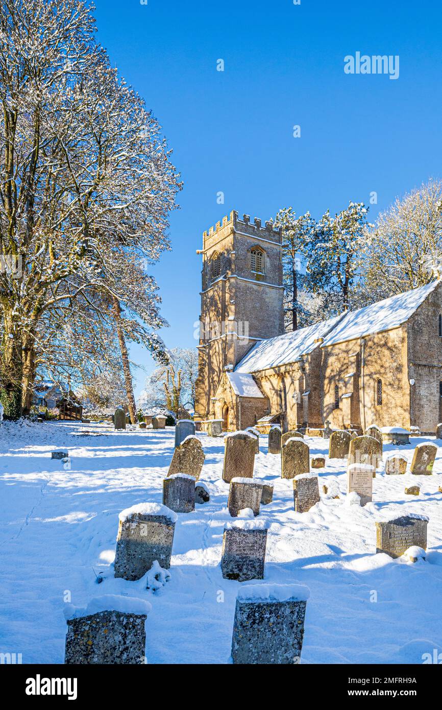 Début hiver neige à l'église de St John l'évangéliste dans le village Cotswold d'Elkstone, Gloucestershire, Angleterre Royaume-Uni Banque D'Images