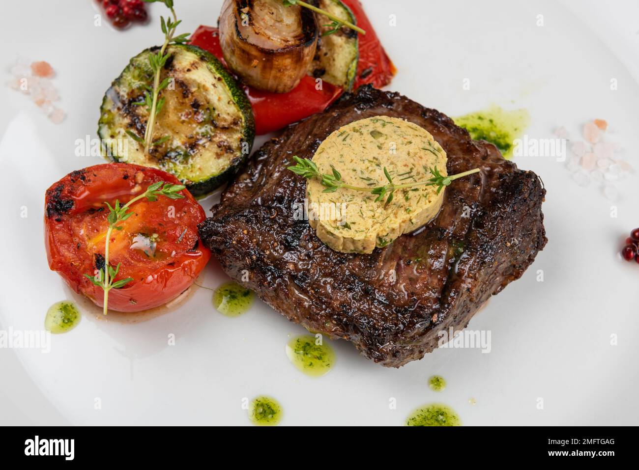 Filet de bœuf angus noir grillé avec légumes sur plaque blanche sur fond de bois noir Banque D'Images