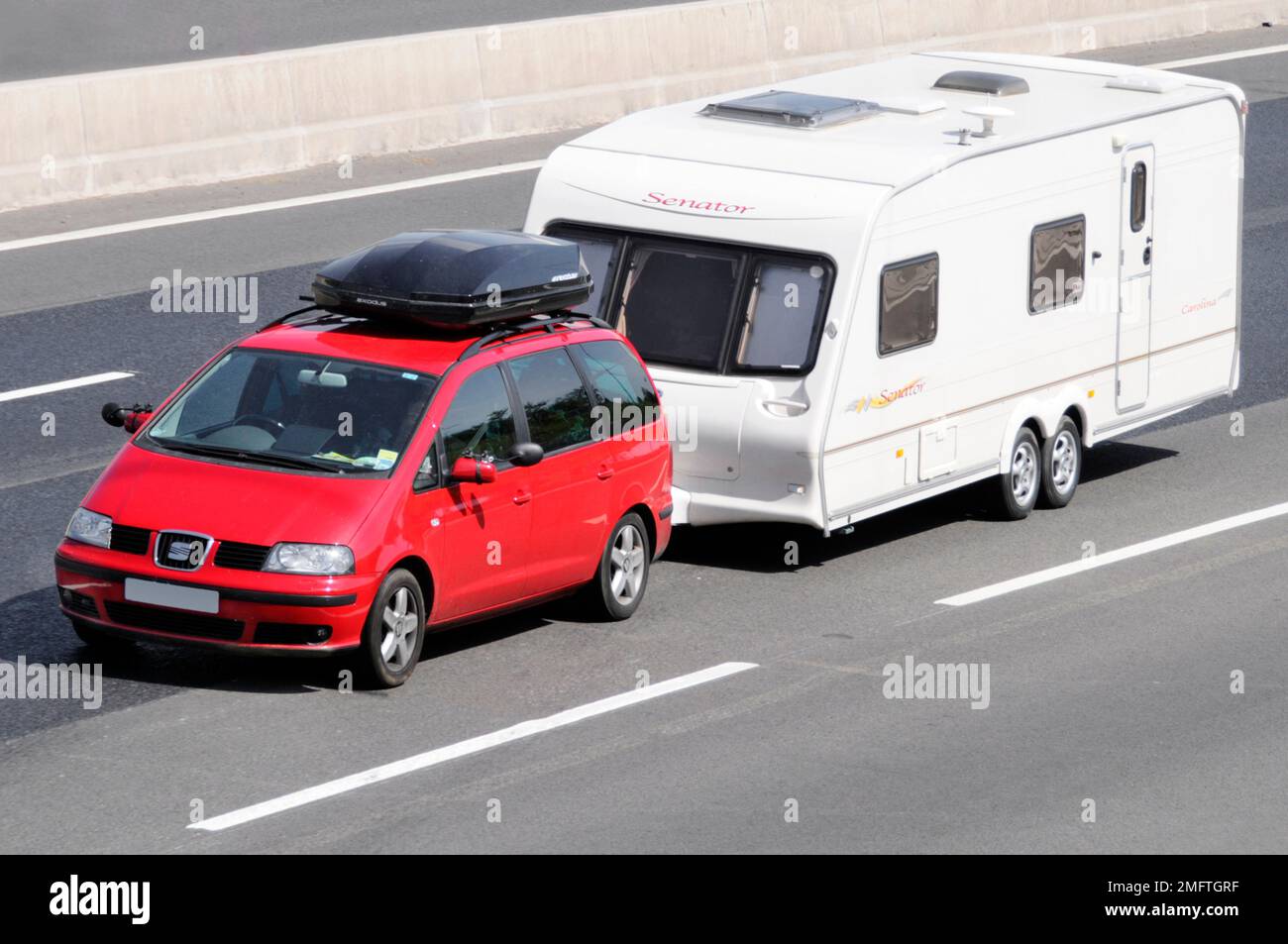 SEAT marque cinq portes voiture rouge équipée coffre de toit noir coffre de voiture remorque blanche Senator caravane à deux essieux conduisant le long de la route d'autoroute m25 Essex Angleterre Royaume-Uni Banque D'Images